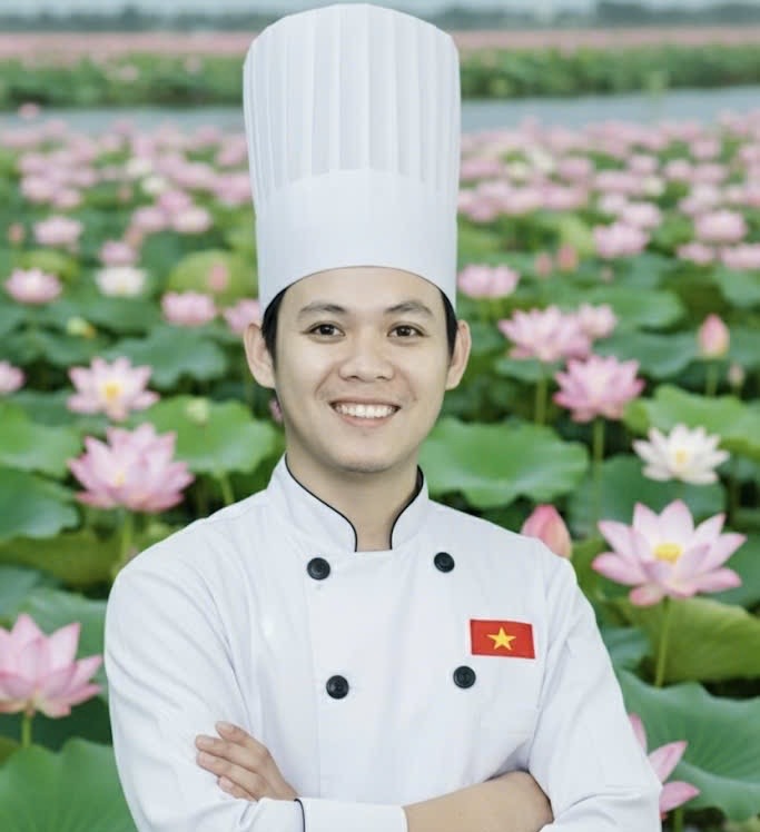 Chân dung Nguyễn Tấn Lực mặc áo bếp trắng và mũ bếp, nền đầm sen Đồng Tháp