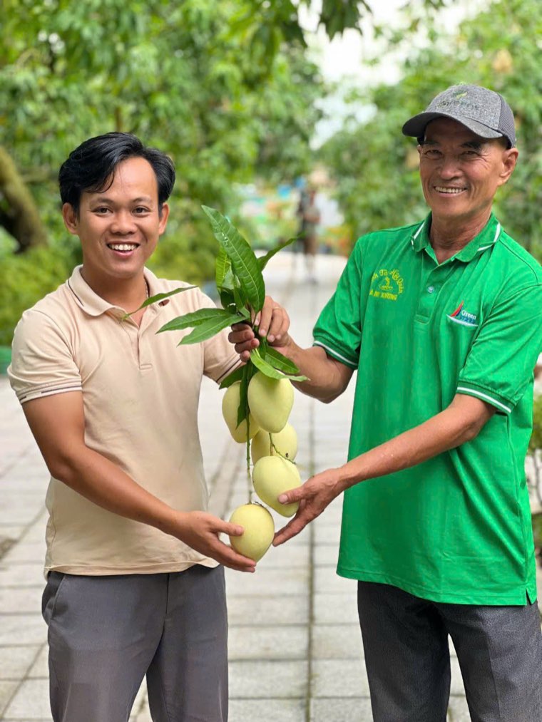 Nguyễn Tấn Lực cùng một nhà vườn cầm chùm xoài vừa hái